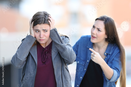 Canvas-taulu Girl accusing her sad friend in the street