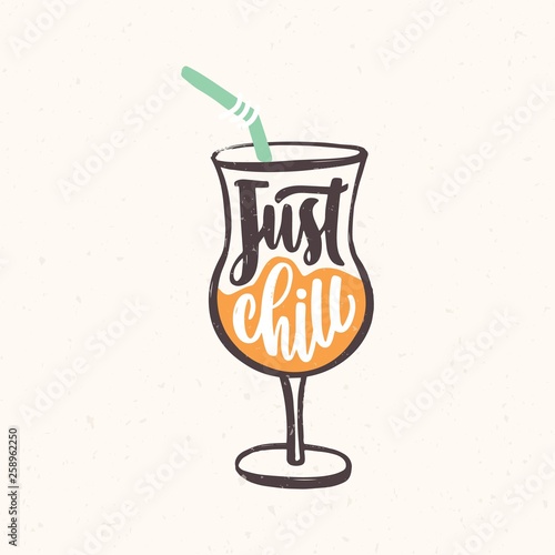 Just Chill slogan handwritten with cursive calligraphic font on glass of exotic cocktail