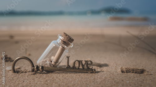 Message In Bottle And Vintage Key On Beach