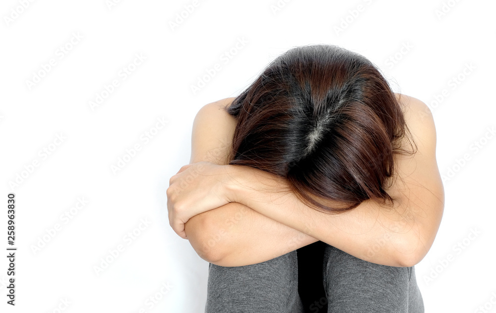 Woman sat sadly strained unhappy on white background .Health concept Woman sat sadly strained unhappy on white background .Health concept