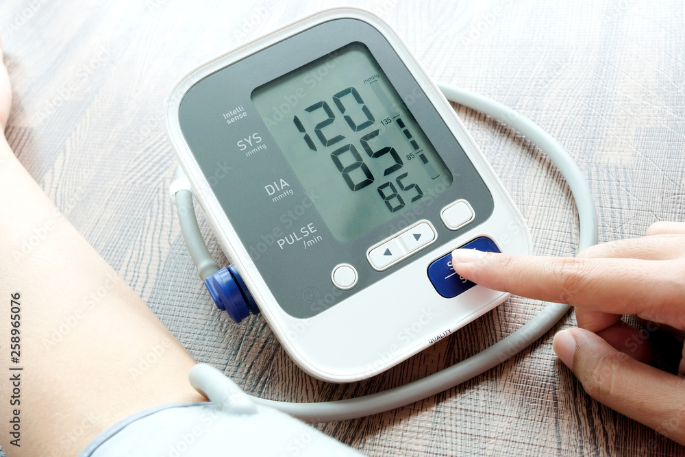 Man check blood pressure monitor and heart rate monitor with digital pressure gauge. Health care and Medical concept Man check blood pressure monitor and heart rate monitor with digital pressure gauge. Health care and Medical concept