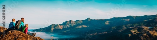 mother and kids hiking in mountains, family travel in nature