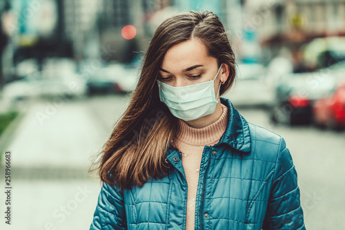 Woman in medical mask on street. Protection against virus, infection, exhaust and industrial emissions in urban. Air pollution and epidemic in city