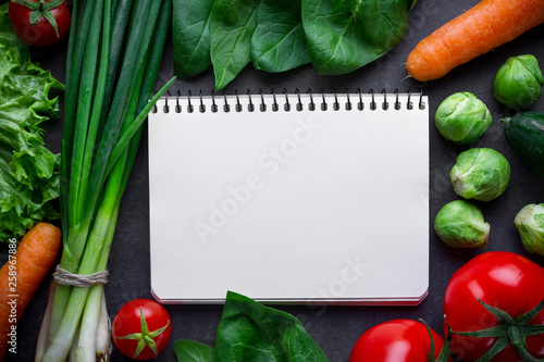 Blank recipe book and ripe ingredients for cooking fresh healthy vegetables dishes. Clean food and balanced diet. Copy space. Diet plan, control food and diary