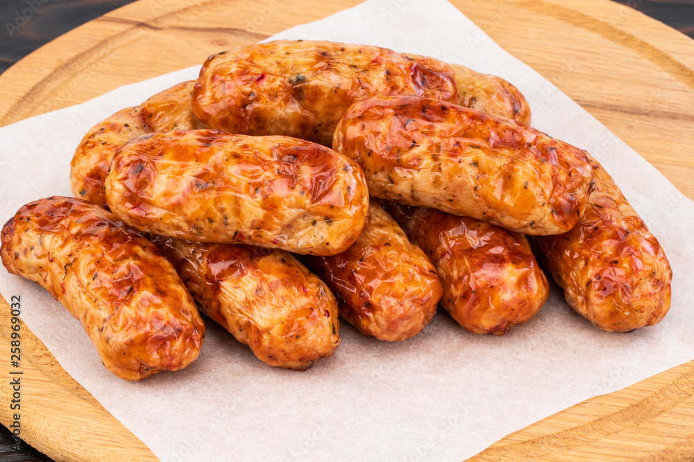 Tasty grilled sausage on the wooden background