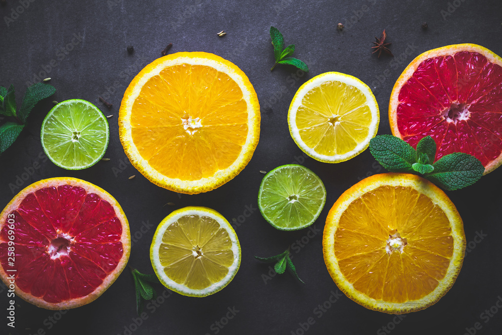 Fresh, ripe citrus fruits and green mint leaves on dark background. Healthy food and diet. Vitamins and vitamin с Fresh, ripe citrus fruits and green mint leaves on dark background. Healthy food and diet. Vitamins and vitamin с