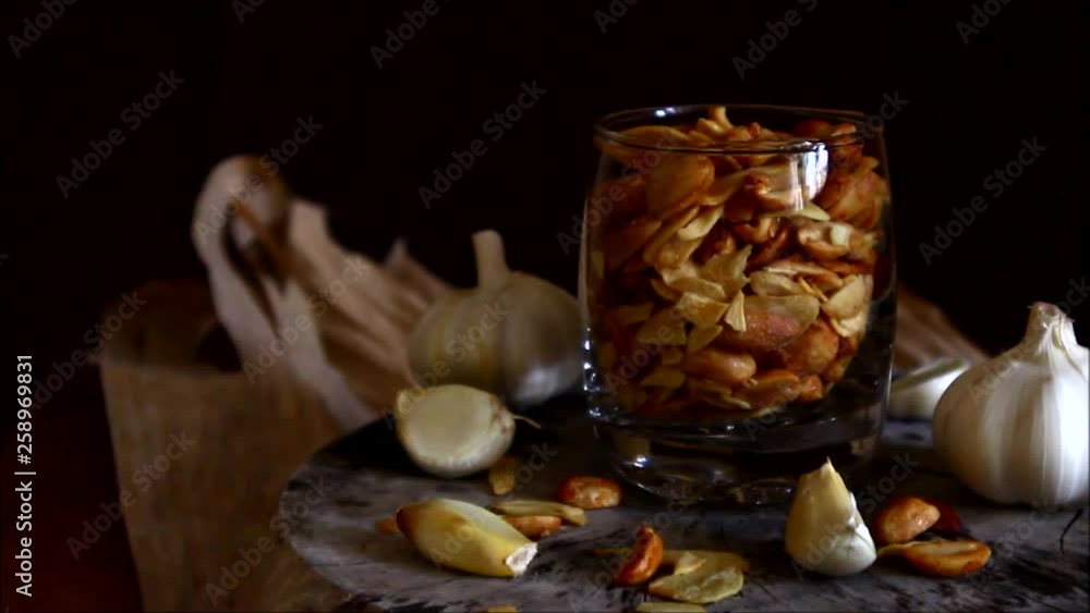 Tilting up with moving lights video shot of toasted peanuts and garlic chips Tilting up with moving lights video shot of toasted peanuts and garlic chips