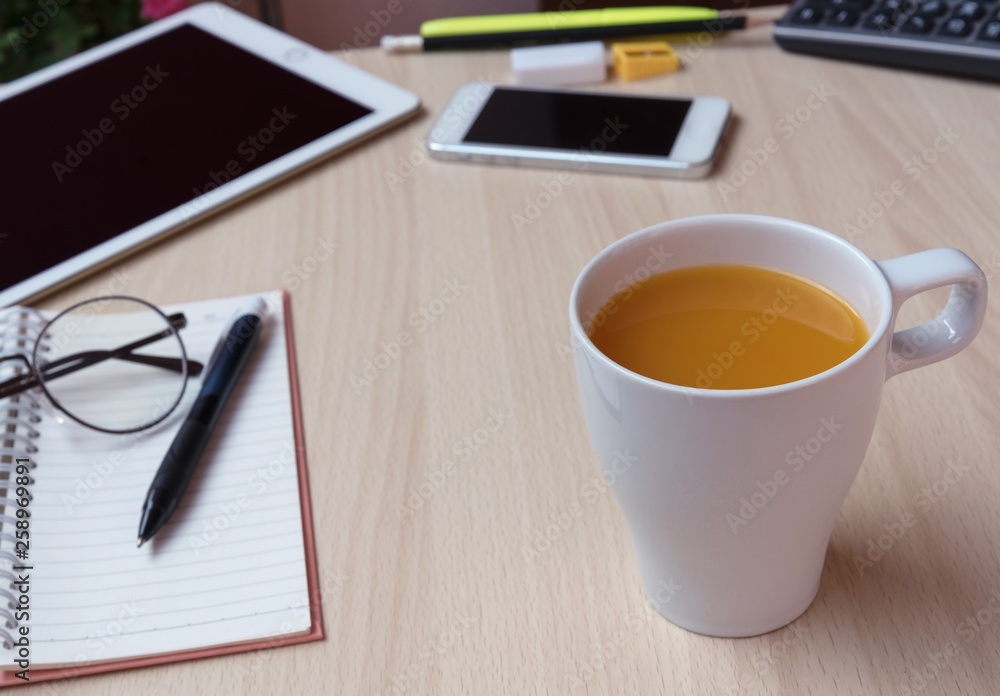 Open blank page notebook on wood table with smart phone, glasses, calculator beside in morning time business concept. Open blank page notebook on wood table with smart phone, glasses, calculator beside in morning time business concept.