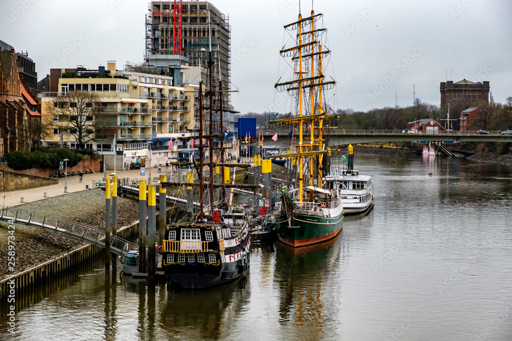 Alexander von Humboldt tall ship and others wooden sailing ships and barg floating on the banks of the River Weser in Bremen, Germany. March 2019