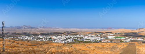 Spain, Lanzarote, XXL panorama of teguise village houses and palm trees in endless volcanic landscape