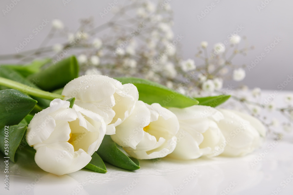 Bouquet of fresh white tulips covered with dew drops on white background. Tulip petals covered with water drops Bouquet of fresh white tulips covered with dew drops on white background. Tulip petals covered with water drops