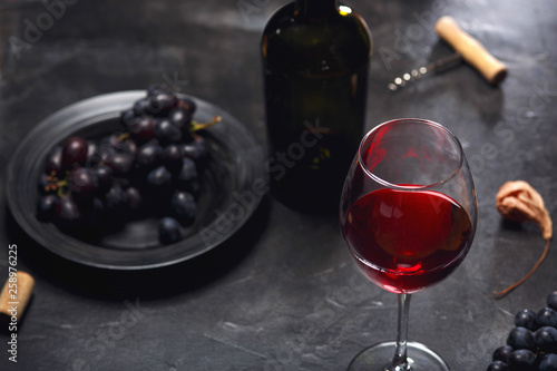 red wine and grapes. Wine and grapes in vintage setting with corks on wooden table