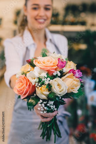 closeup florist holding bouquet of roses