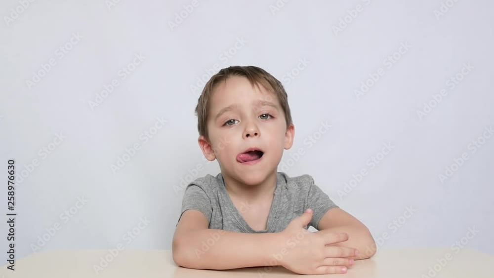 A small child sits at the table and does the articulation of the language. Classes with speech therapist. The development of children of preschool age. A small child sits at the table and does the articulation of the language. Classes with speech therapist. The development of children of preschool age.