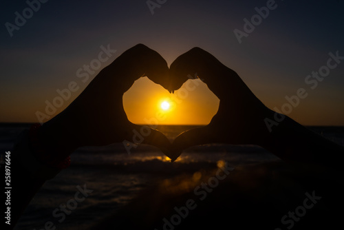 Hand in the shape of a heart during sunset on the beach Falasarne  Greece  Crete