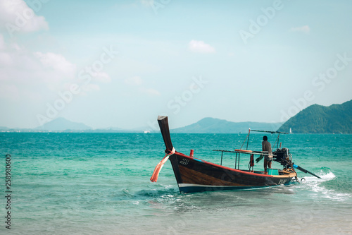 a man riding small boat in phuket island  Thailand. Beautiful landscape of blue sea and mountains. Concept of active people enjoying holiday and sharing moments