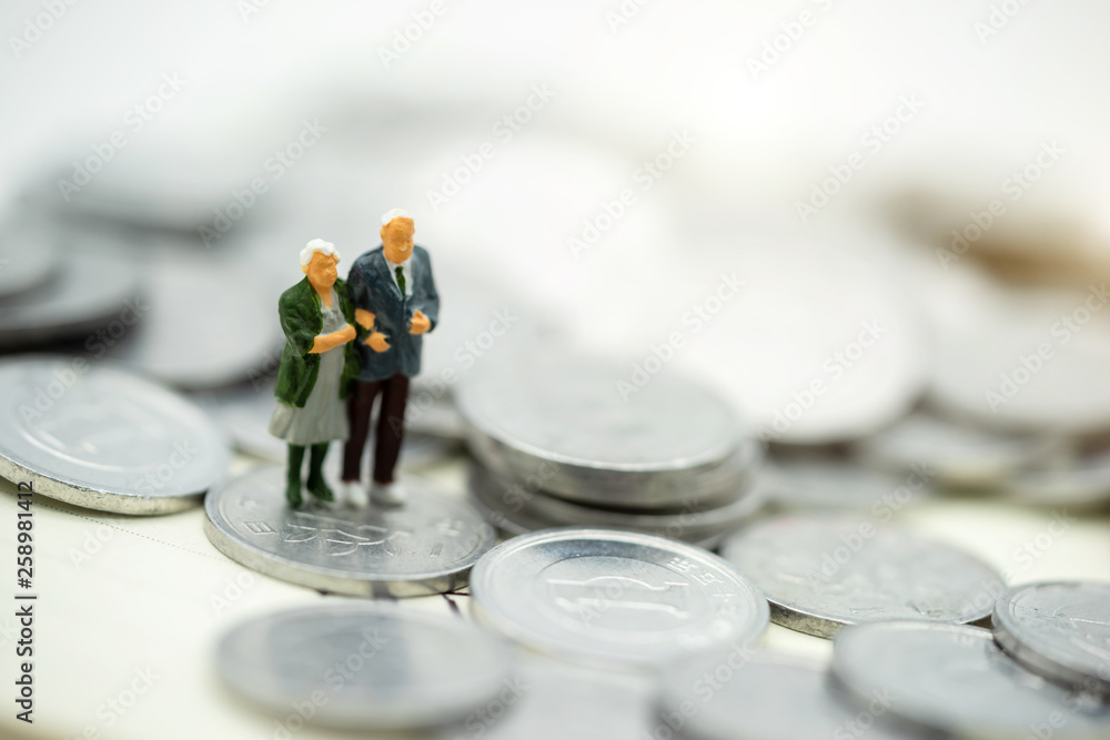 Miniature people: Happy old people standing on coins stack, Retirement planning, Emergency plan, Life insurance and Financial Concept. Miniature people: Happy old people standing on coins stack, Retirement planning, Emergency plan, Life insurance and Financial Concept.