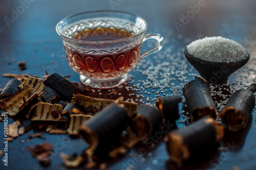 Golden shower tree or garmalo or Amaltas or Cassia fistulatea in a transparent glass cup along with sugar on wooden surface used in the treatment of constipation. photo