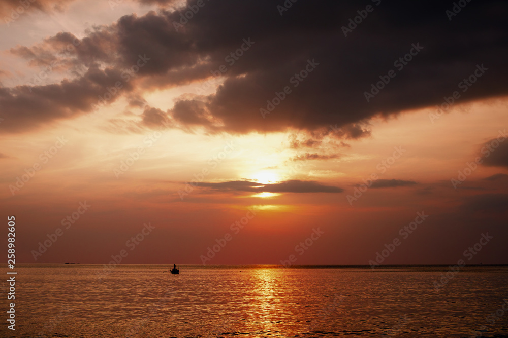 Thailand sea in evening with sun set and small boat in the middle the sea during twilight sky