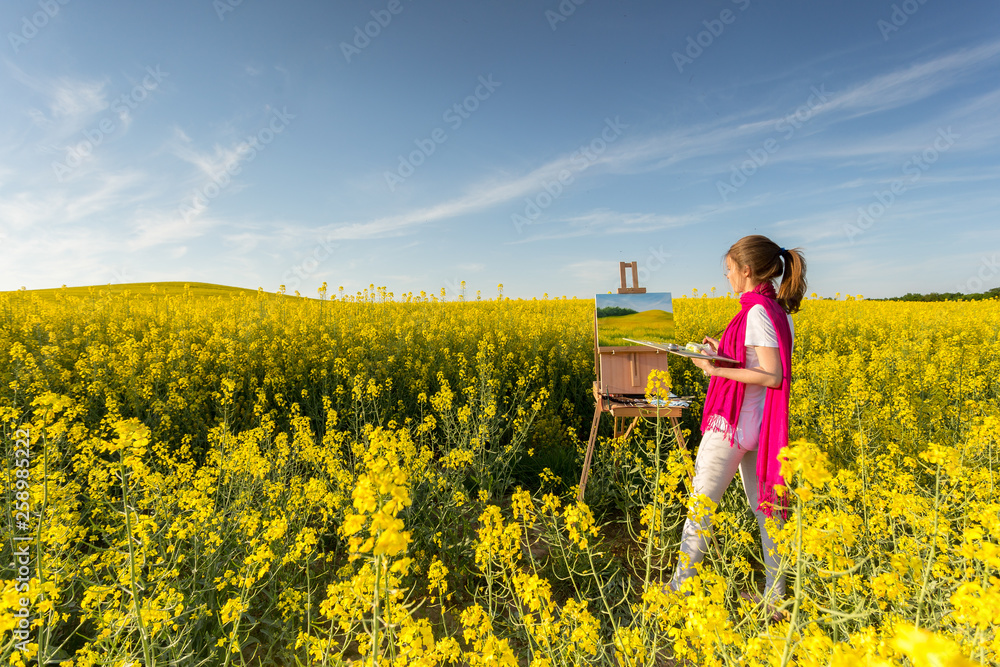 girl painter with an easel in a yellow rapeseed field girl painter with an easel in a yellow rapeseed field
