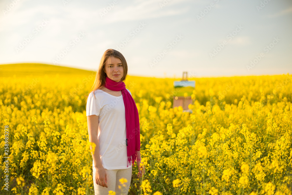girl painter with an easel in a yellow rapeseed field girl painter with an easel in a yellow rapeseed field