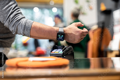 Customer paying contactless with his smartwatch