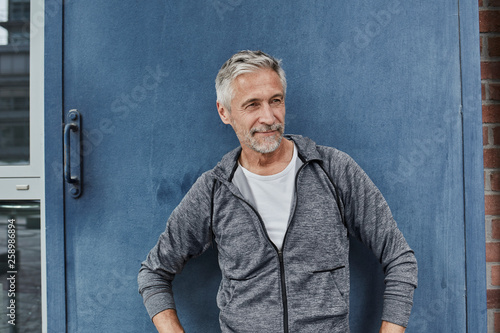 Portrait of mature man wearing tracksuit top in front of gym photo