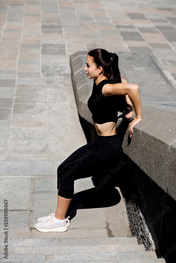 Brunette fit woman stretching at the street Brunette fit woman stretching at the street