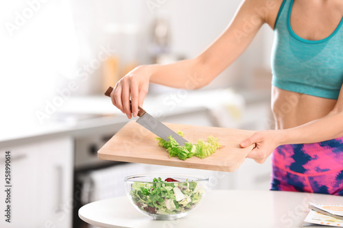 Young woman in fitness clothes preparing healthy breakfast at home, closeup