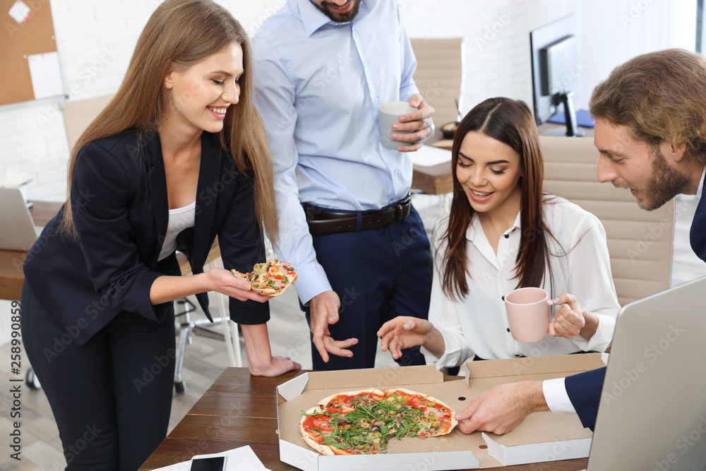 Office employees having pizza for lunch at workplace. Food delivery