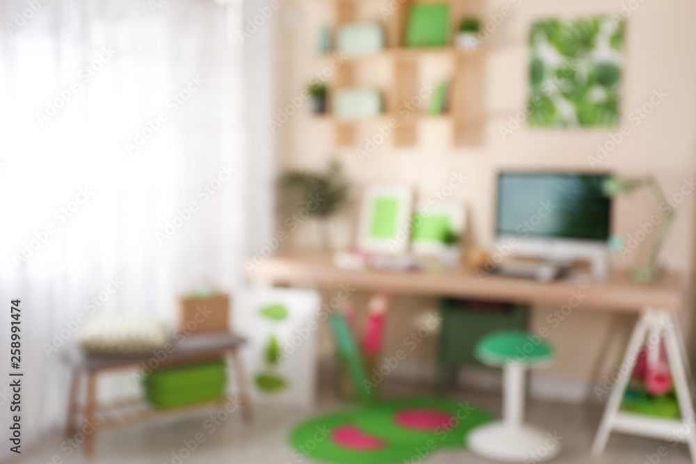 Fototapeta premium Blurred view of comfortable workplace with computer at home