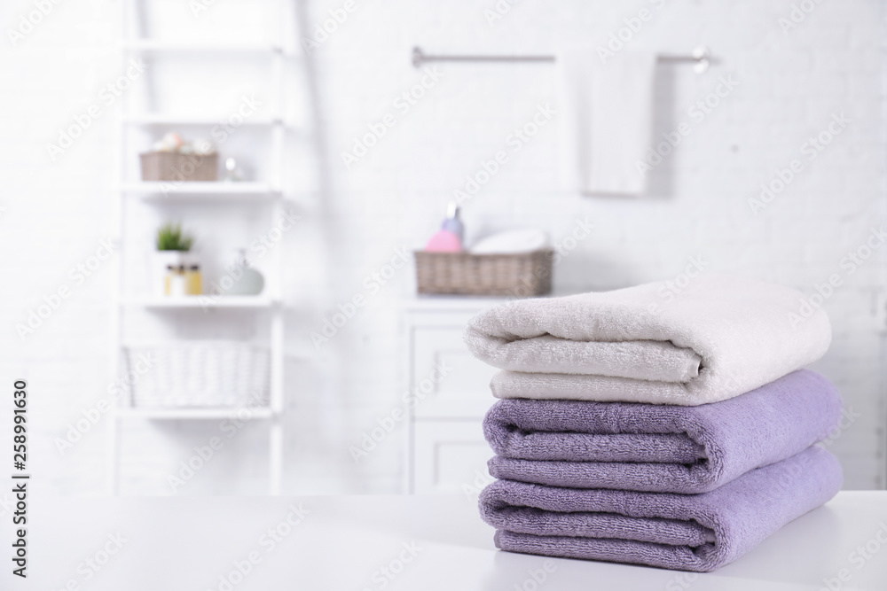 Stack of fresh towels on table in bathroom. Space for text Stack of fresh towels on table in bathroom. Space for text