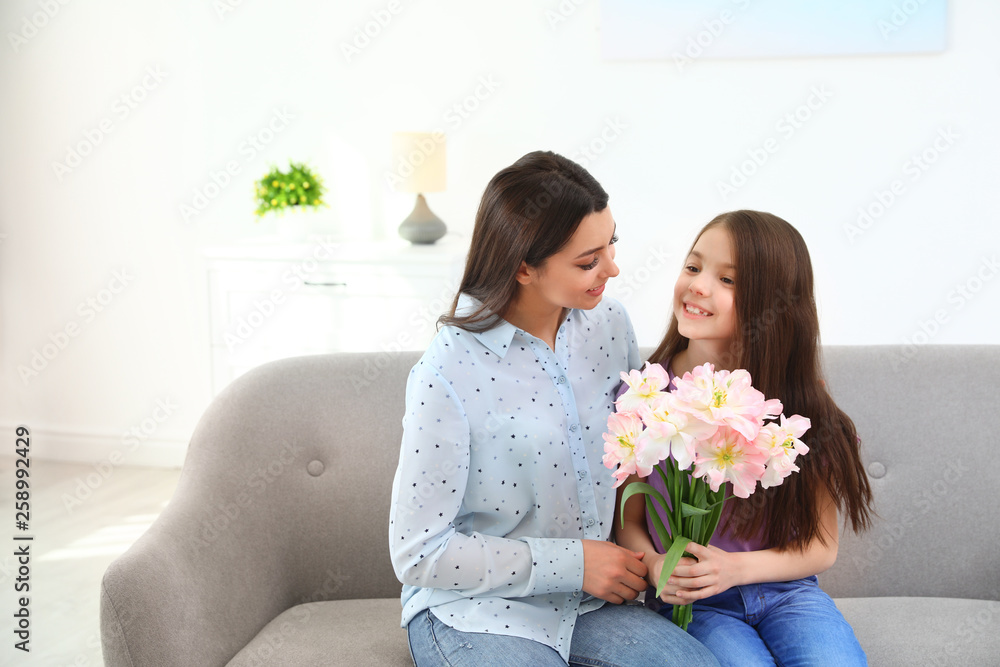 Little daughter congratulating her mom at home, space for text. Happy Mother's Day Little daughter congratulating her mom at home, space for text. Happy Mother's Day