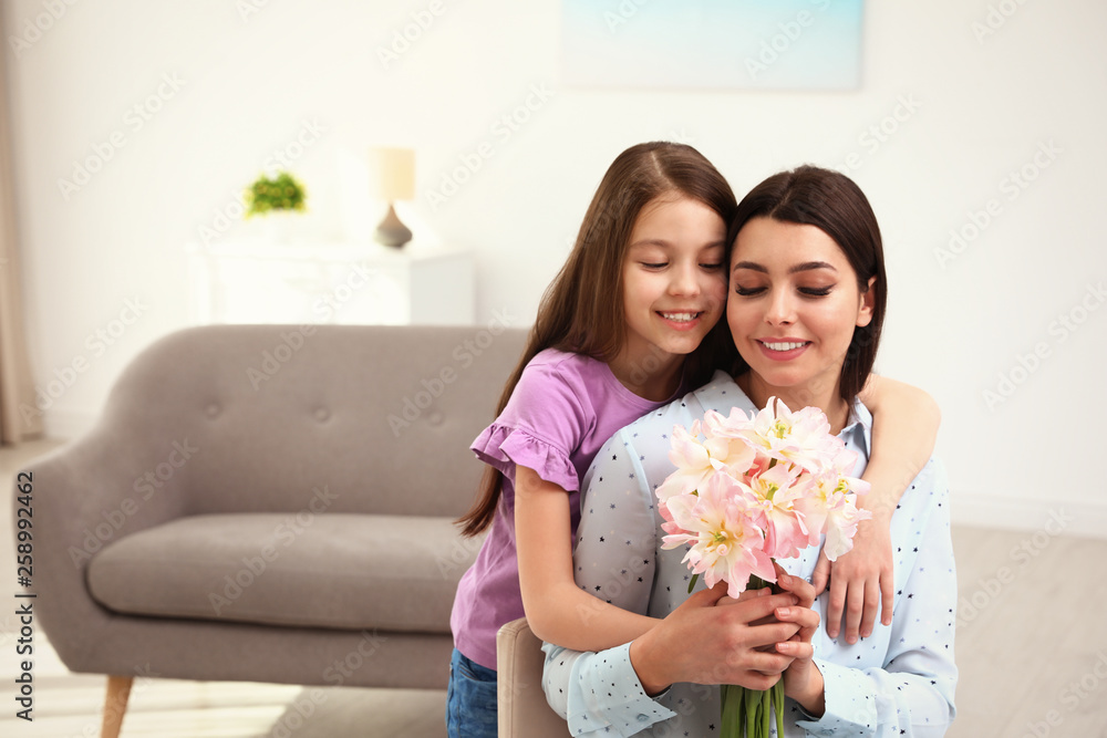 Little daughter congratulating her mom at home, space for text. Happy Mother's Day Little daughter congratulating her mom at home, space for text. Happy Mother's Day