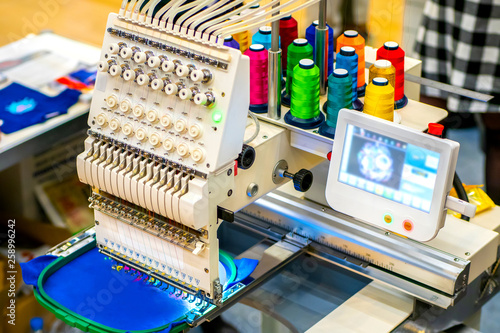 Embroidery Machine. Embroidery machine with computer control. Industrial embroidery equipment. Programmable embroidery machine. Embroidery patterns. photo