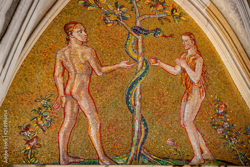 Photo Bible scene of Genesis with Adam and Eva at major entrance portal of Saint Vitus