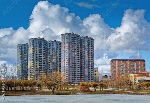 Photography Urban houses and sky with clouds reflected in puddle from melting snow on street