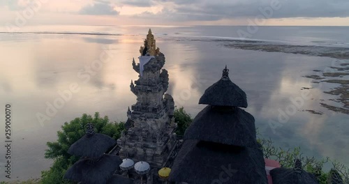 Aerial top view of Pura Geger temple at sunrise on the ocean, Bali. 4K photo