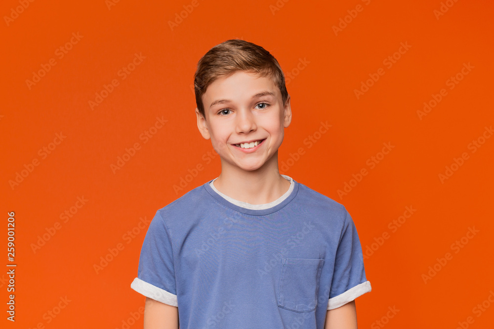 Portrait of young boy on orange background - obrazy, fototapety, plakaty 