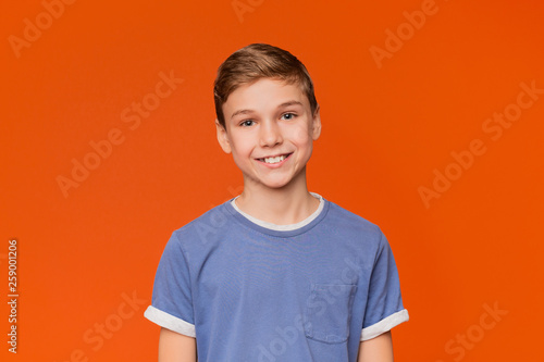 Portrait of young boy on orange background