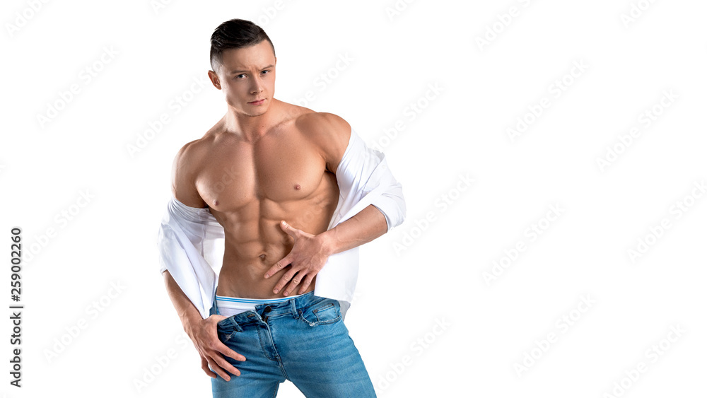 Man in blue jeans and white shirt touching his perfect abs isolated on white. Man in blue jeans and white shirt touching his perfect abs isolated on white.