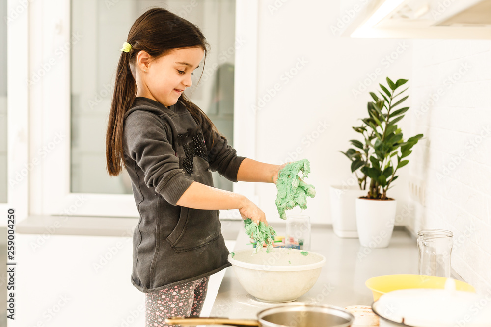 Little cute girl is cooking on kitchen. Having fun while making cakes and cookies. Smiling Little cute girl is cooking on kitchen. Having fun while making cakes and cookies. Smiling