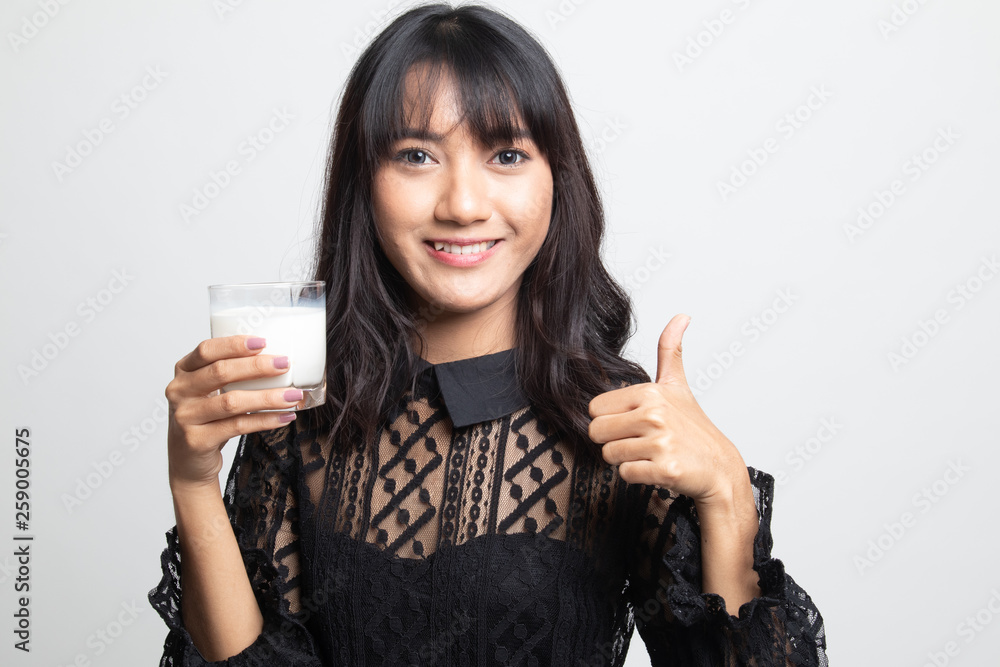 Healthy Asian woman drinking a glass of milk thumbs up. Healthy Asian woman drinking a glass of milk thumbs up.