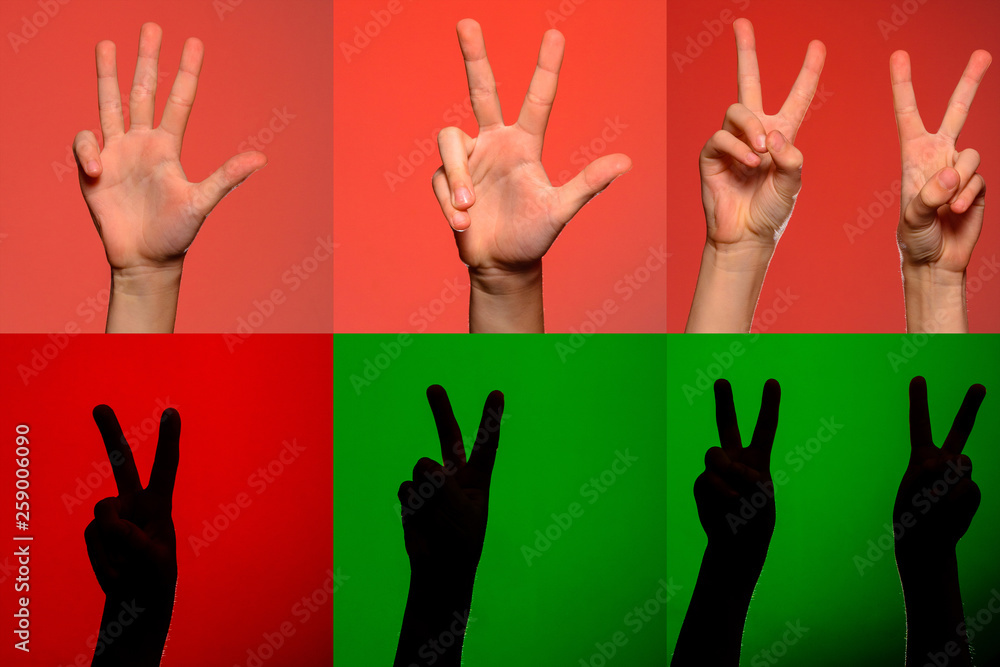 A set of characters on the fingers of human hands that are depicted by silhouettes on an isolated green background A set of characters on the fingers of human hands that are depicted by silhouettes on an isolated green background