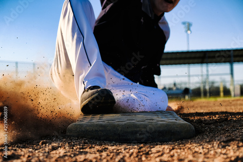 Photography Baseball player slide into base, sports action close up.