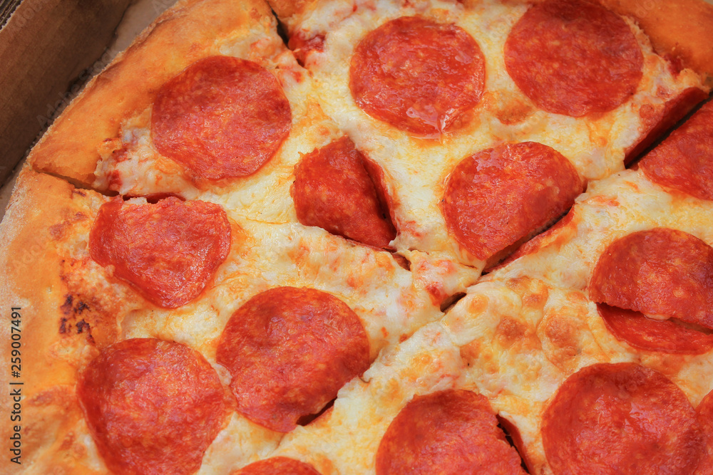 Pepperoni pizza sliced tasty italian meal close up image. Fresh classic pepperoni pizza recipe of hot pizza on with pepperoni sausage, melted mozzarella and parmesan cheese and tomato sauce toppings Pepperoni pizza sliced tasty italian meal close up image. Fresh classic pepperoni pizza recipe of hot pizza on with pepperoni sausage, melted mozzarella and parmesan cheese and tomato sauce toppings