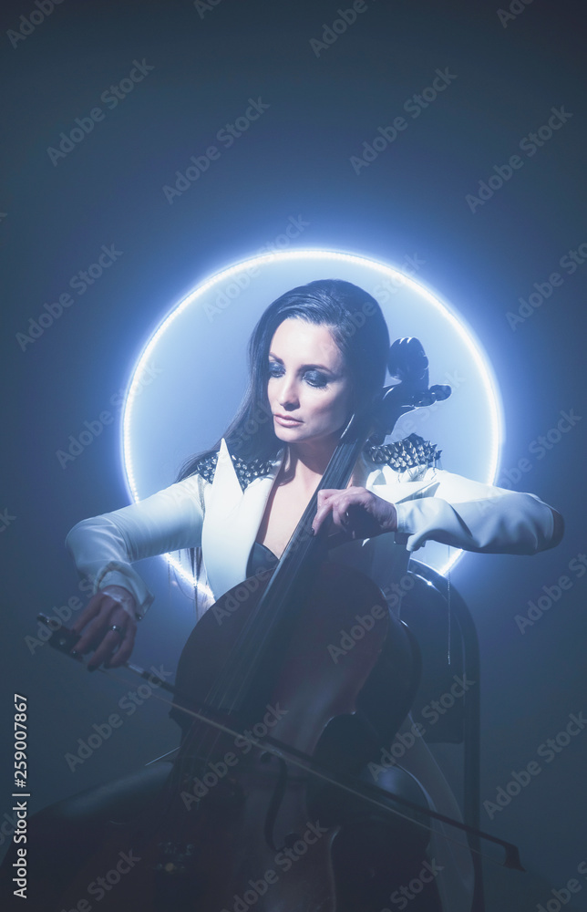 Beautiful woman in a white coat plays the cello Beautiful woman in a white coat plays the cello
