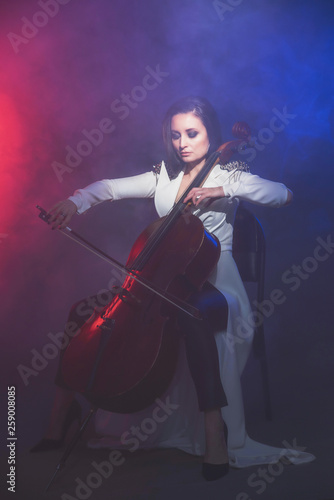 Beautiful woman in a white coat plays the cello © Антон Фрунзе
