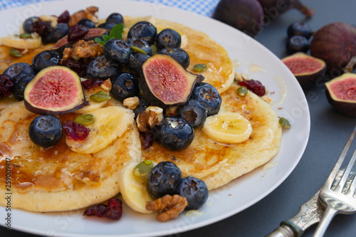 Pancakes with blueberries, mint, fruits and honey for breakfast - homemade healthy food. Breakfast idea.