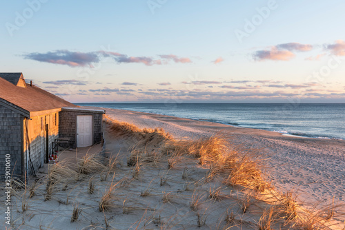 Sunlight lighting Building and Sand Dunes at Cape Cod with View of Ocean photo